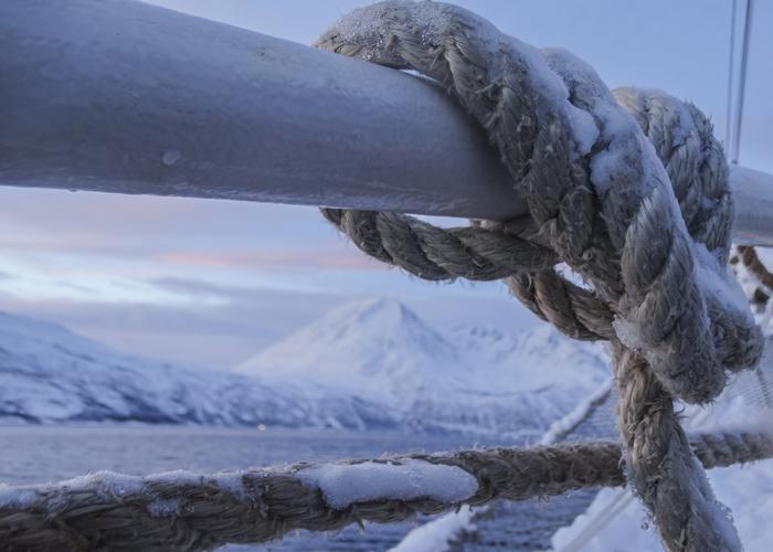 Hand holding black machined steel mechanical pencil with brass tip and top.