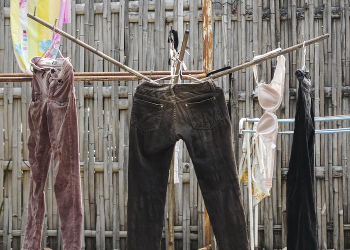 Hand holding black machined steel mechanical pencil with brass tip and top.